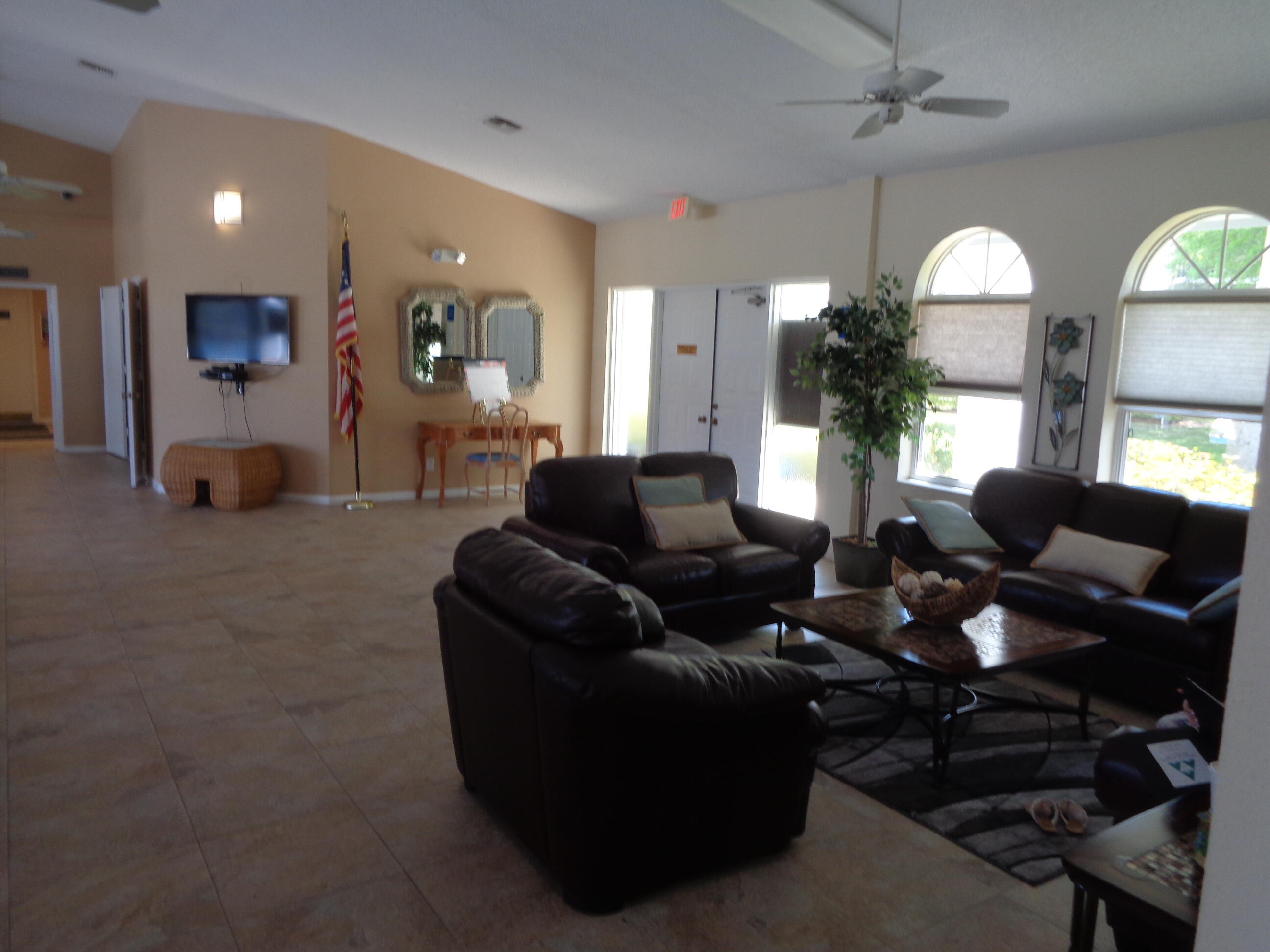 2518 Southeast Anchorage Cove, Unit G2 Port St. Lucie, FL 34952 - Photo 19 of 37 a living room with furniture a chandelier and a flat screen tv