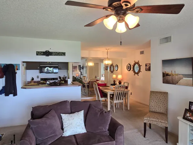 a living room with furniture a chandelier and a dining room