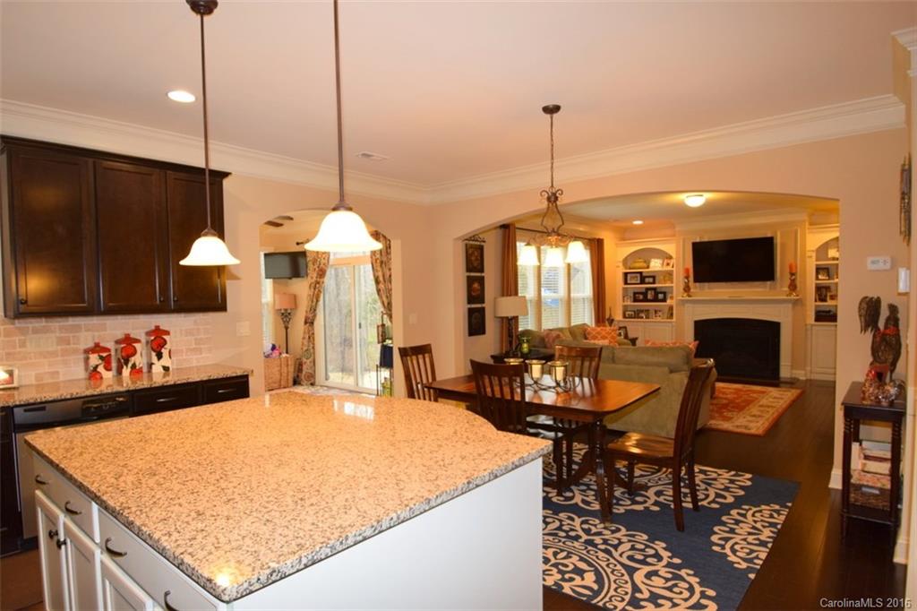 3034 Fallondale Road Waxhaw, NC 28173 - Photo 7 of 22 a dining table with a fireplace and open kitchen view