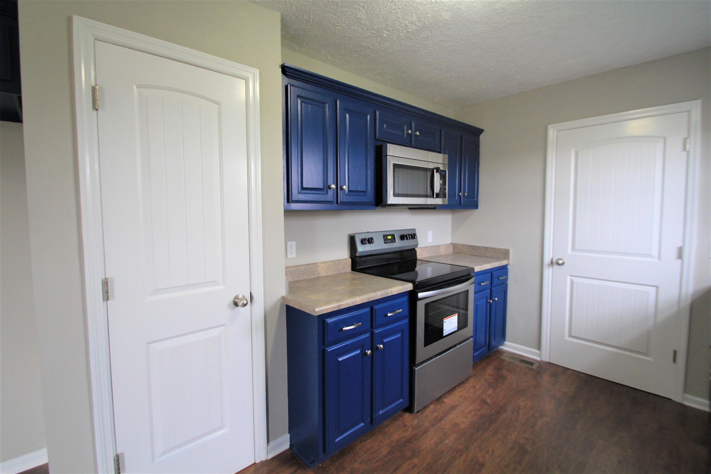 131 Spry Road Morrison, TN 37357 - Photo 4 of 11 a kitchen with stainless steel appliances granite countertop a stove microwave and sink