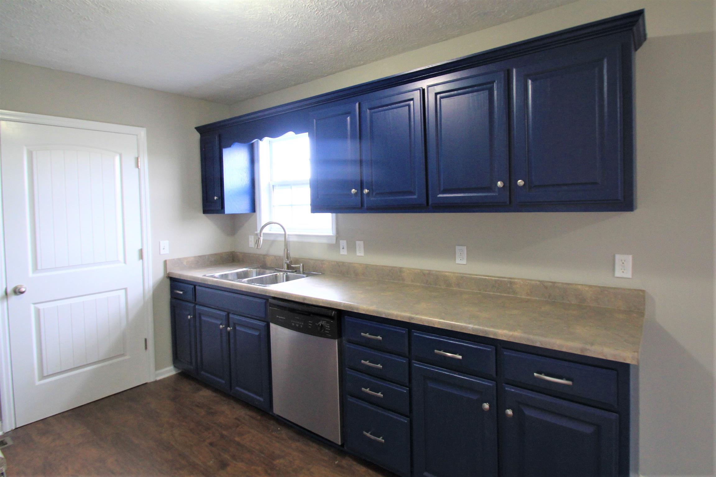 131 Spry Road Morrison, TN 37357 - Photo 5 of 11 a kitchen with stainless steel appliances granite countertop a sink dishwasher and cabinets with wooden floor
