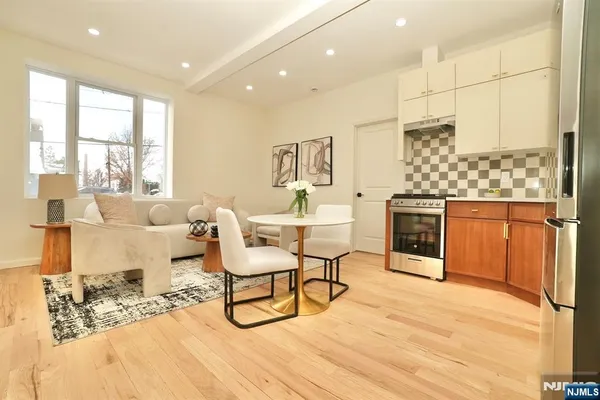 a living room with furniture a rug and a kitchen view