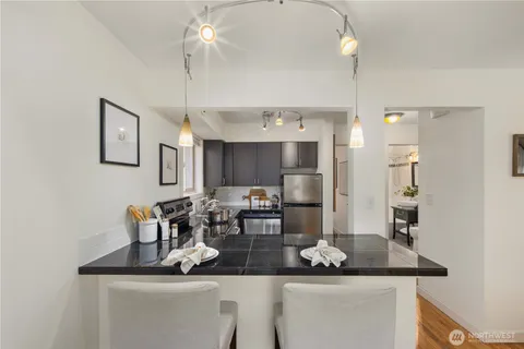 a kitchen with a dining table chairs cabinets and stainless steel appliances