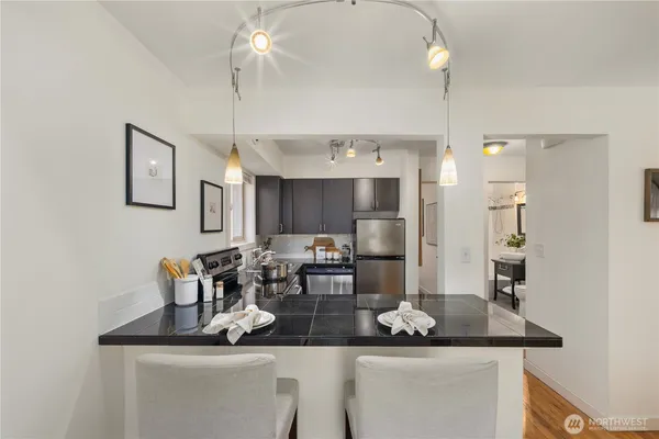 a kitchen with a dining table chairs cabinets and stainless steel appliances
