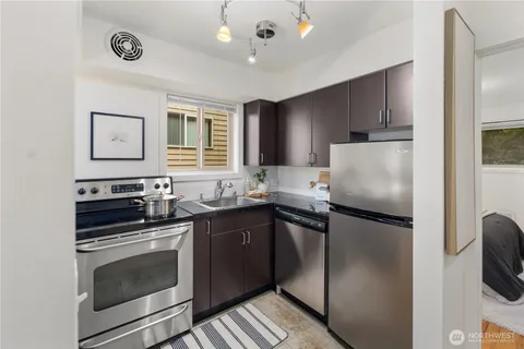 a kitchen with granite countertop a refrigerator stove and microwave
