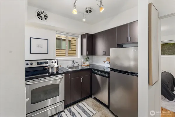a kitchen with granite countertop a refrigerator stove and microwave