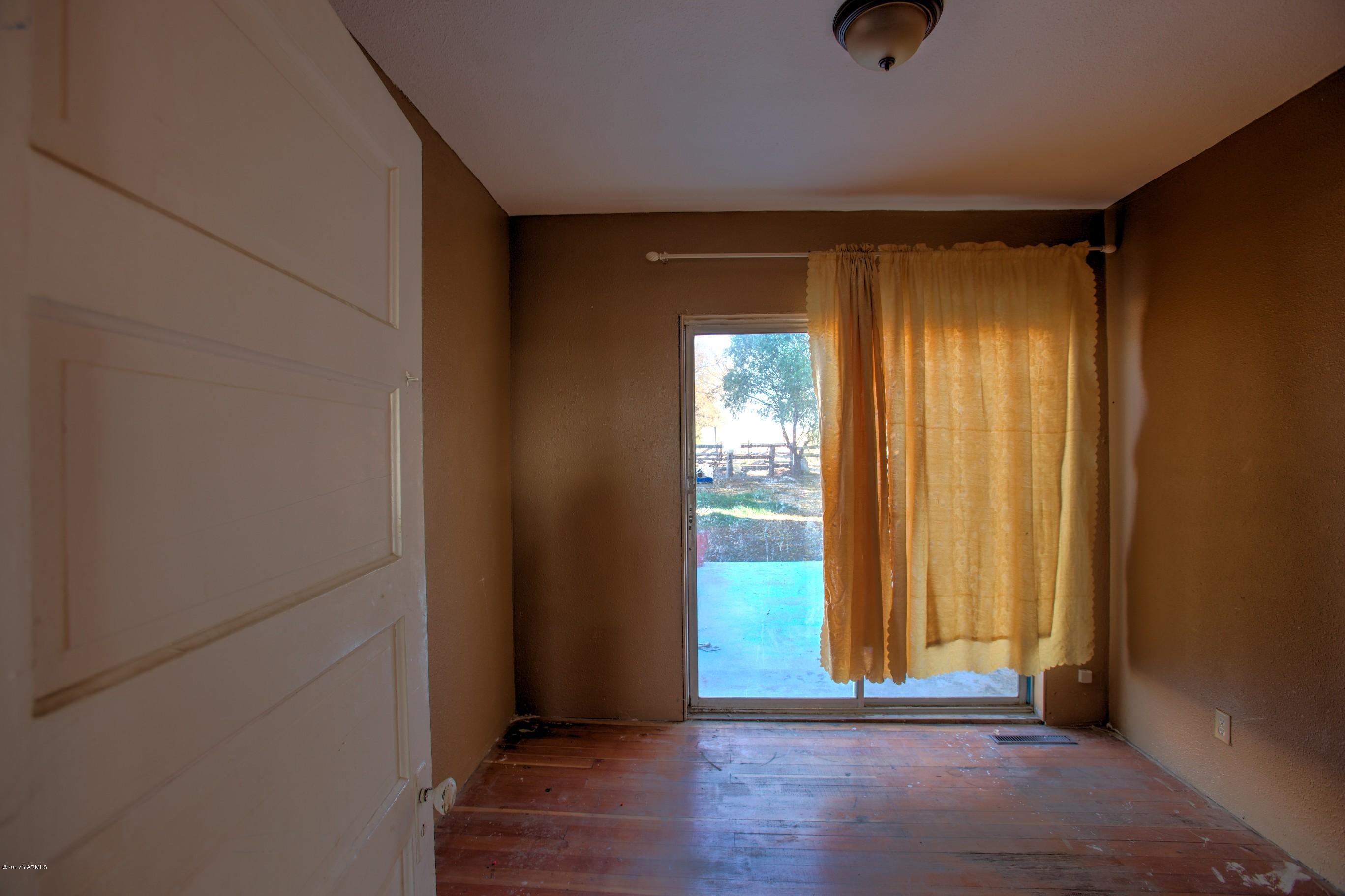 2771 Fordyce Road Sunnyside, WA 98944 - Photo 12 of 21 a view of an empty room with wooden floor and a window