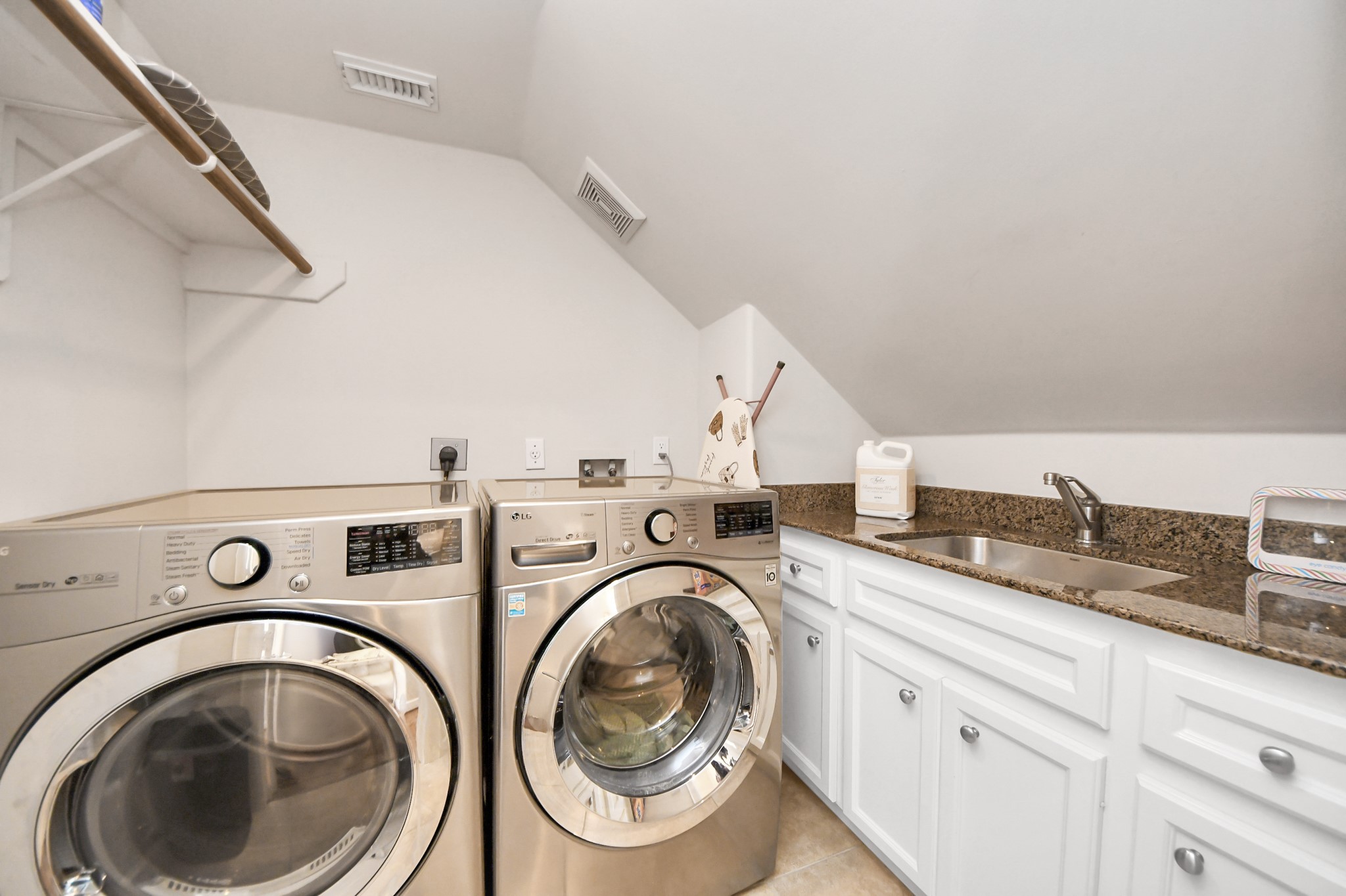 6302 Hermann Lake Drive Houston, TX 77021 - Photo 41 of 50 The laundry room is thoughtfully designed for both convenience and functionality. Equipped with a washer and dryer, generous counter space, built-in cabinetry, and a utility sink, this space makes everyday tasks effortless while keeping everything neatly organized.