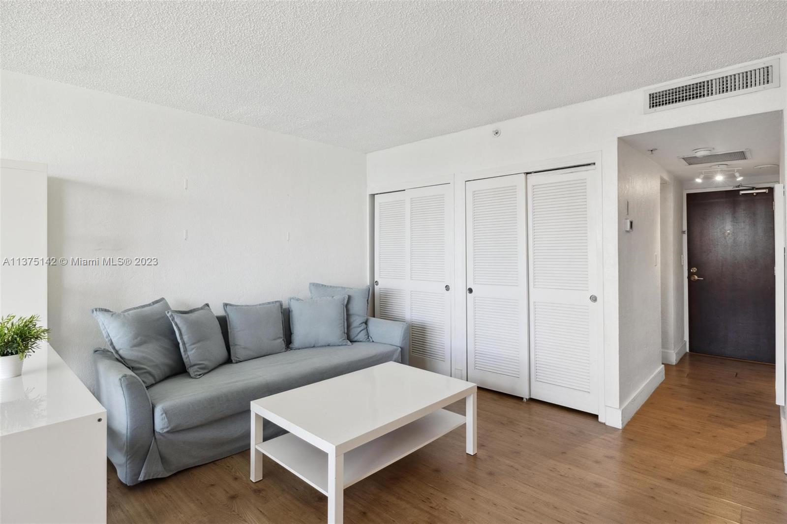 1500 Bay Road, Unit 1556S Miami Beach, FL 33139 - Photo 9 of 13 a living room with furniture and a wooden floor