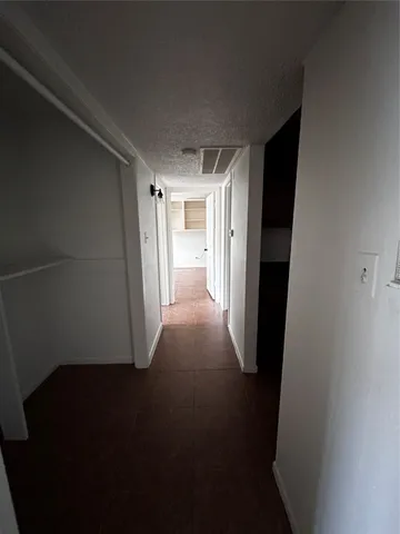 an empty room with windows and ceiling fan