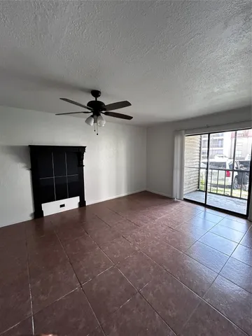 an empty room with windows and fireplace