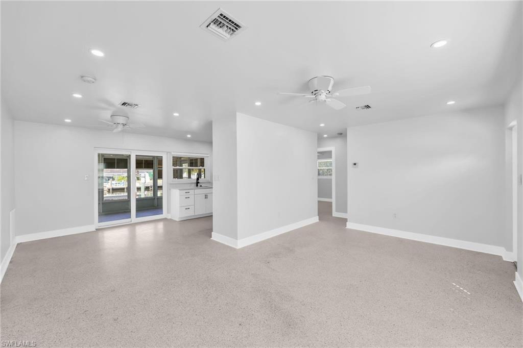 2822 Bruce Street Matlacha, FL 33993 - Photo 12 of 26 an empty room with wooden floor and a kitchen
