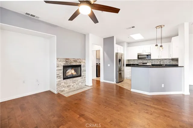 a view of a kitchen with a sink a fireplace and cabinets