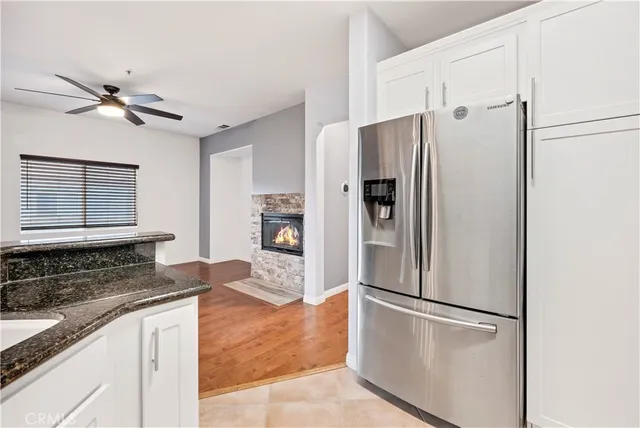 a kitchen with stainless steel appliances granite countertop a refrigerator a stove and a sink