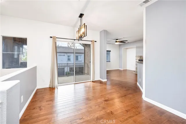 a view of a hallway with wooden floor and a living room