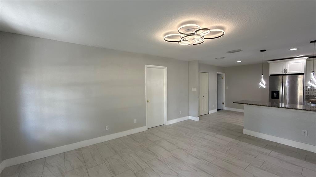 8106 Wichita Way Tampa, FL 33619 - Photo 3 of 21 an empty room with wooden floor and windows