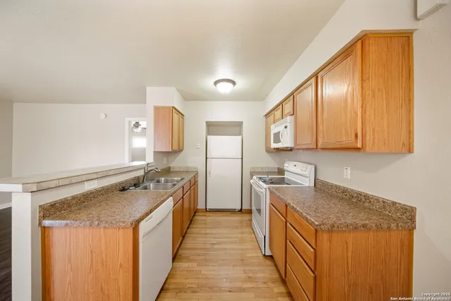 a kitchen with stainless steel appliances granite countertop lots of counter top space and wooden floor