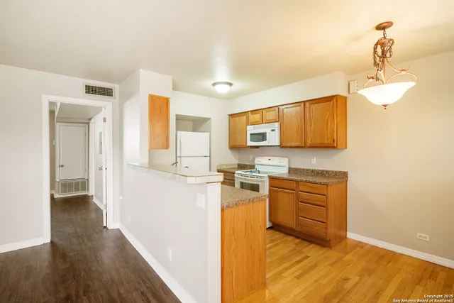a kitchen with stainless steel appliances granite countertop a sink cabinets and wooden floor