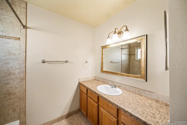 a bathroom with a granite countertop sink and a mirror