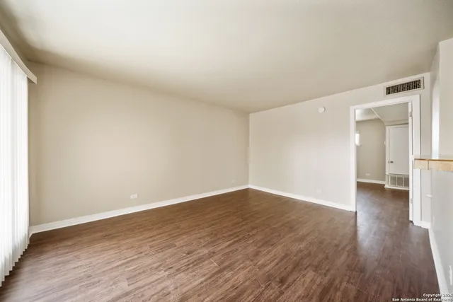 a view of a room with wooden floor and a window
