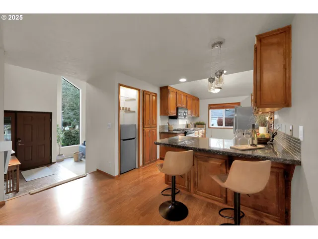 a kitchen with stainless steel appliances granite countertop a sink stove cabinets and wooden floor