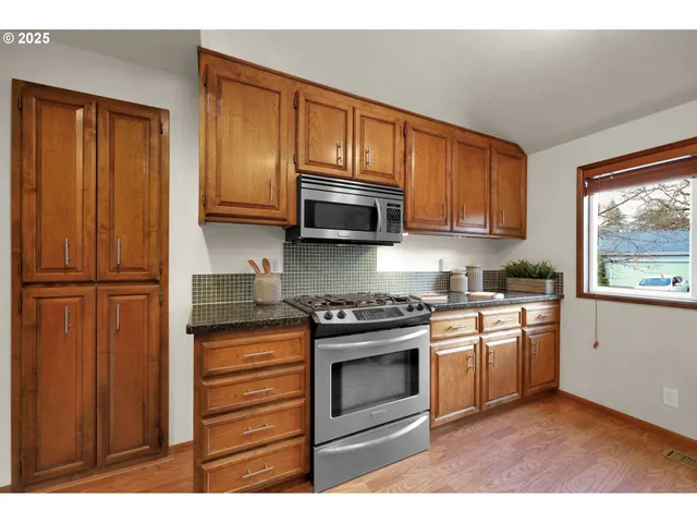 a kitchen with granite countertop a sink stove and cabinets