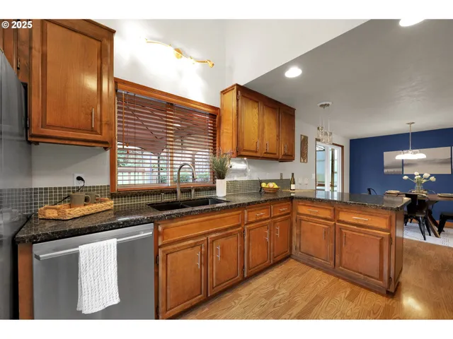 a kitchen with stainless steel appliances granite countertop a refrigerator and a sink
