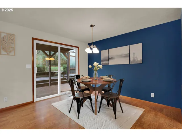 a dining room with furniture a chandelier and wooden floor