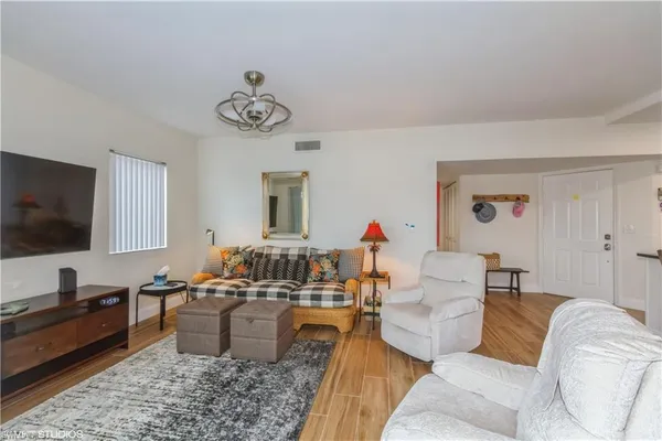 a living room with stainless steel appliances kitchen island granite countertop furniture and a refrigerator