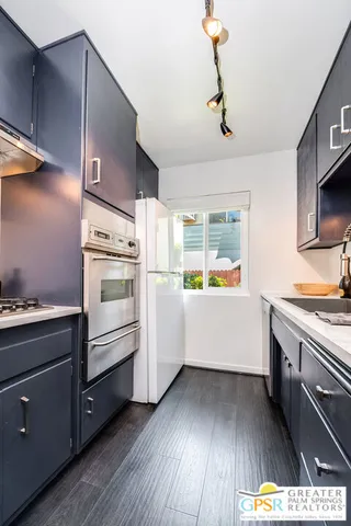 a kitchen with appliances cabinets and a wooden floor