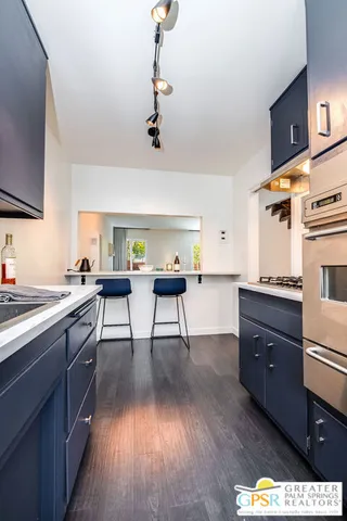 a kitchen with a wooden floor and cabinets