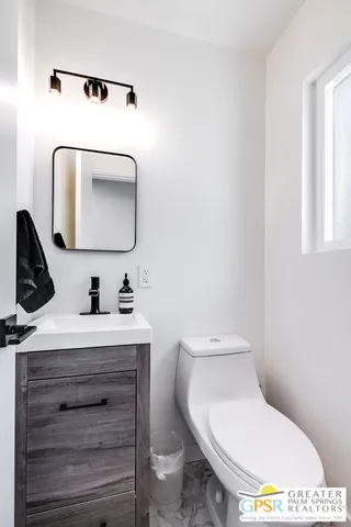 a bathroom with a toilet sink and mirror