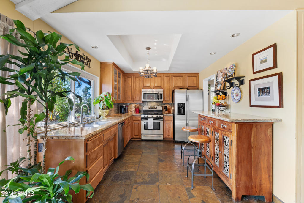 5914 Cochran Street Simi Valley, CA 93063 - Photo 9 of 23 a kitchen with stainless steel appliances kitchen island granite countertop a refrigerator and a stove