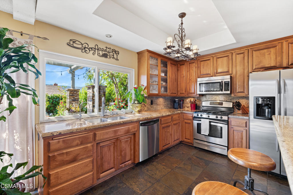 5914 Cochran Street Simi Valley, CA 93063 - Photo 10 of 23 a kitchen with stainless steel appliances granite countertop a stove top oven a sink dishwasher a dining table and chairs with wooden floor