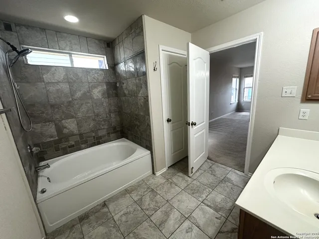 a bathroom with a sink a toilet a tub and shower
