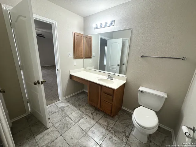 a bathroom with a toilet sink and mirror
