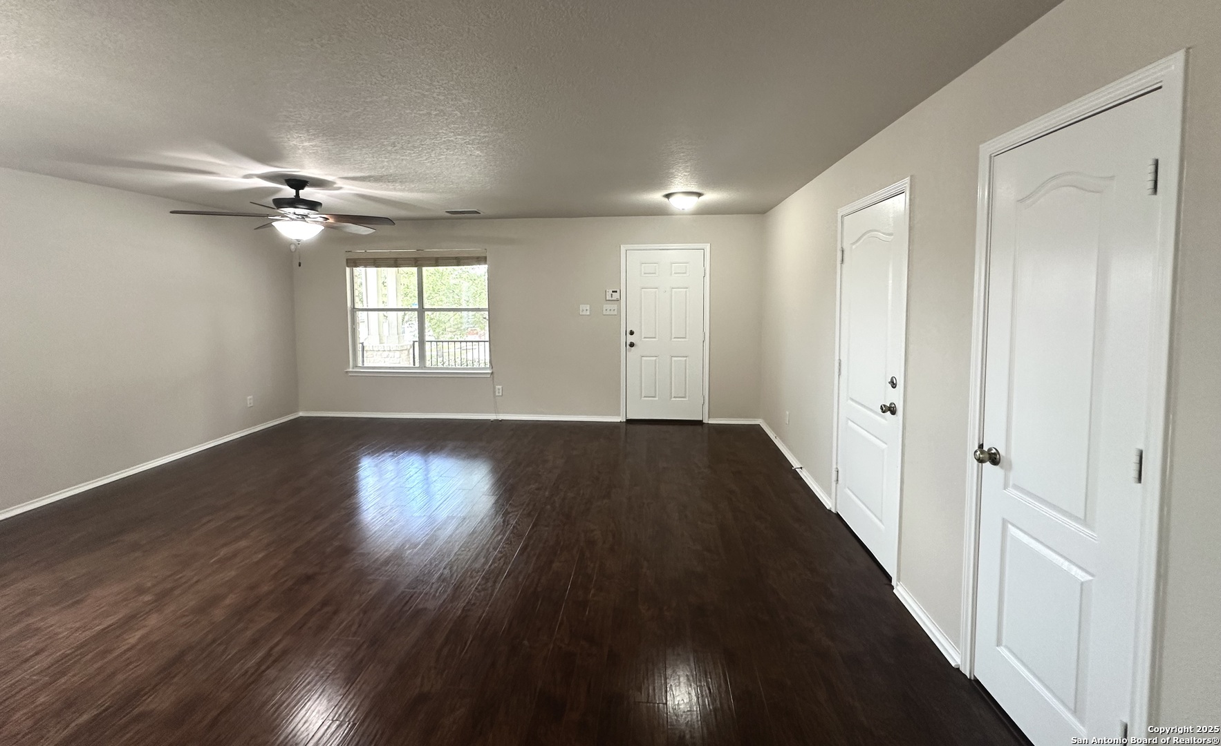 6741 Wayman Ridge Live Oak, TX 78233 - Photo 4 of 25 an empty room with wooden floor fan and windows