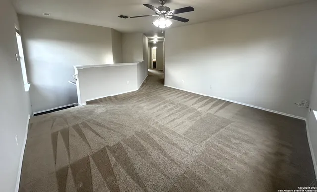 a view of a livingroom with a ceiling fan and window