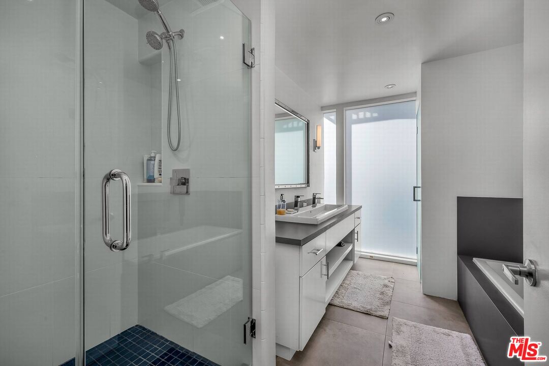 5515 Pacific Avenue, Unit 1 Marina del Rey, CA 90292 - Photo 34 of 45 a bathroom with a granite countertop sink a mirror and a shower