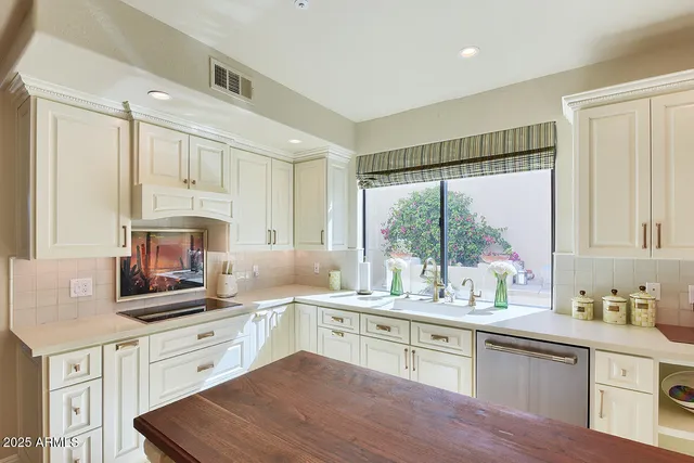 a spacious bedroom with a large bed and a chandelier