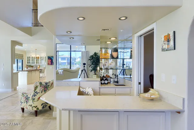 a view of a patio with couches table and chairs under an umbrella with a barbeque