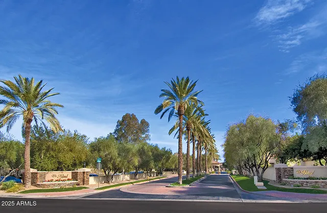 a kitchen with stainless steel appliances granite countertop a refrigerator a stove a kitchen island a dining table and chairs