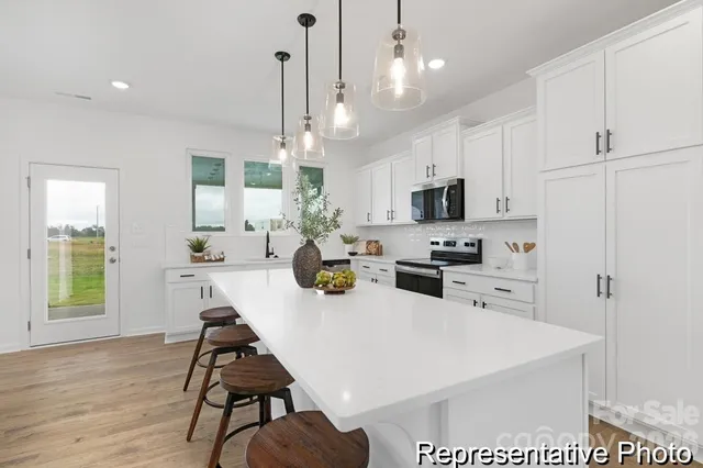 a kitchen with sink a counter and chairs