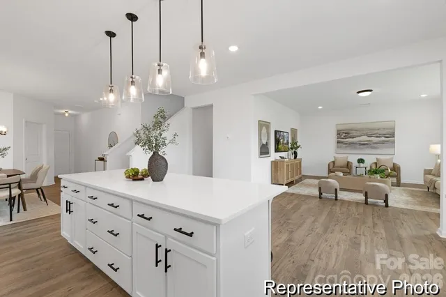 a view of a dining room and livingroom with furniture wooden floor a chandelier