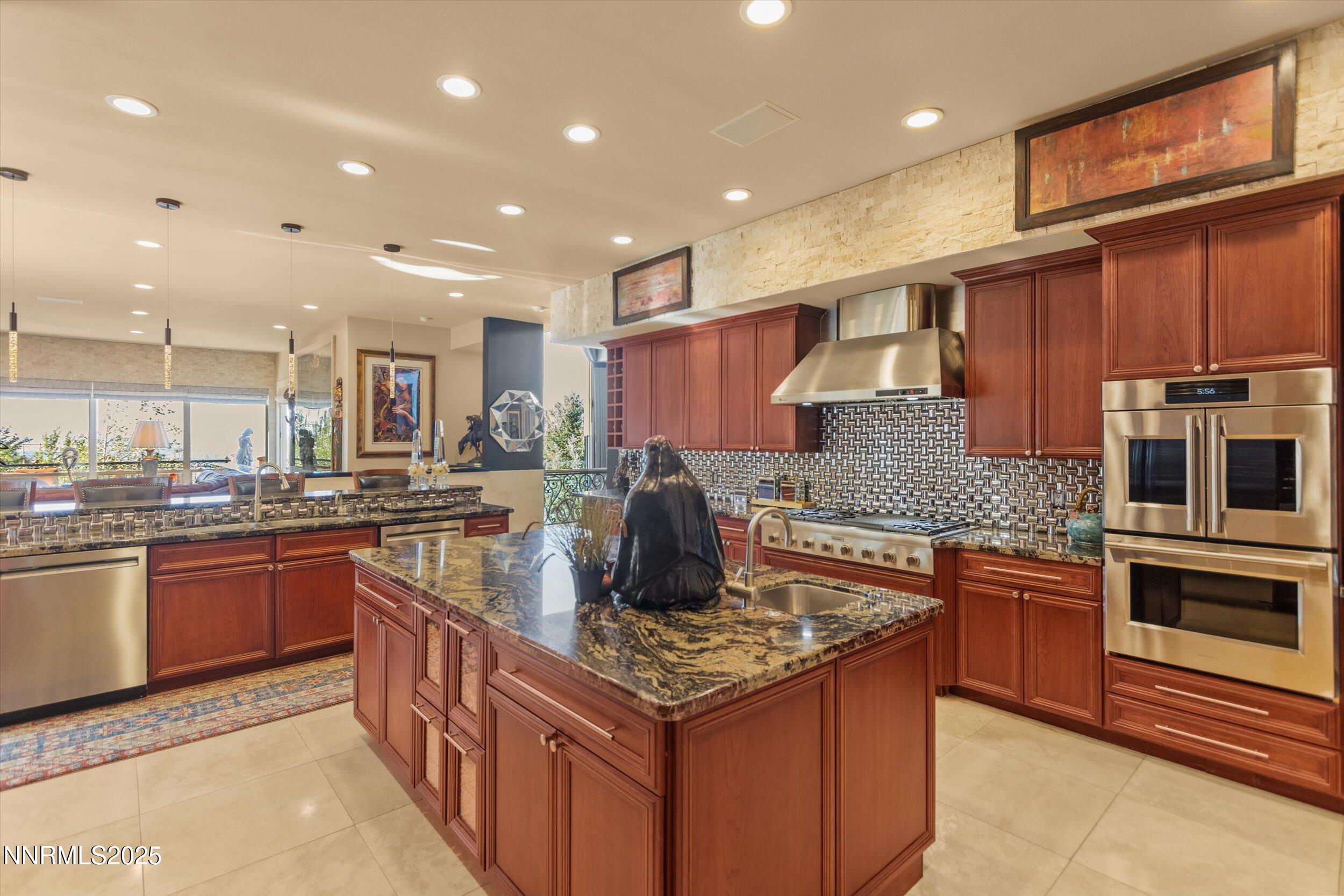 10411 Copper Cloud Drive Reno, NV 89511 - Photo 12 of 54 a kitchen with stainless steel appliances granite countertop a stove top oven a sink dishwasher a dining table and chairs