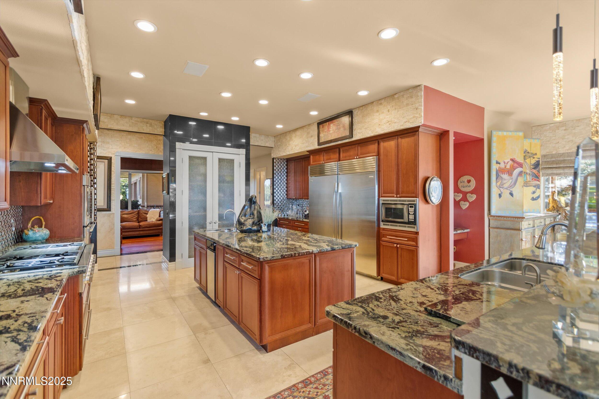 10411 Copper Cloud Drive Reno, NV 89511 - Photo 10 of 54 a kitchen with stainless steel appliances granite countertop counter space and wooden floors