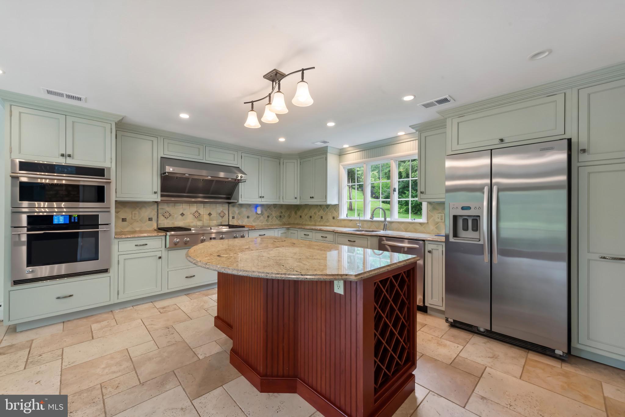 13409 Cambria Farms Road Phoenix, MD 21131 - Photo 16 of 54 a kitchen with kitchen island a sink stainless steel appliances and cabinets
