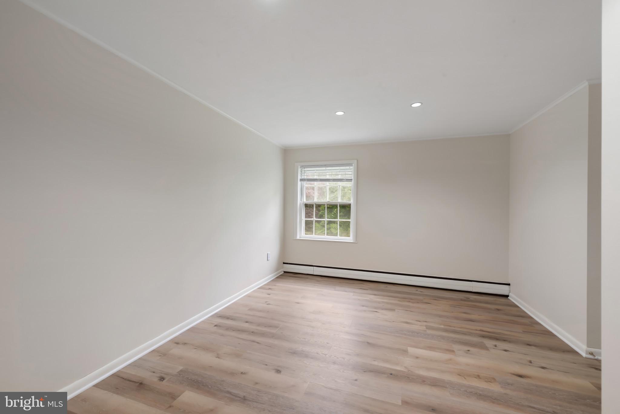 13409 Cambria Farms Road Phoenix, MD 21131 - Photo 34 of 54 a view of an empty room with wooden floor and a window