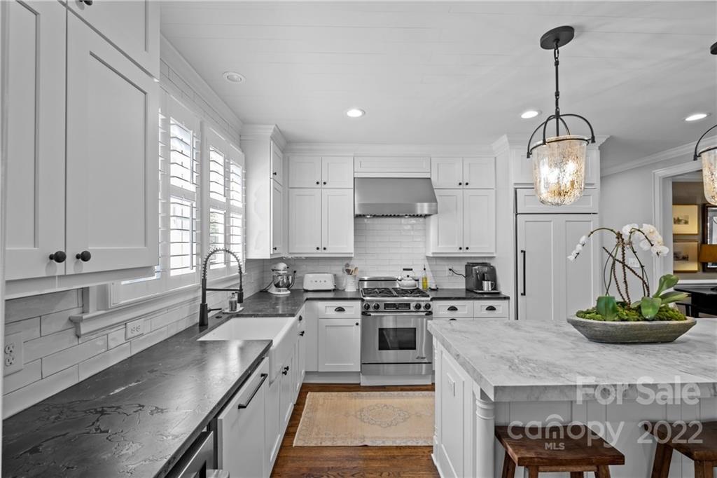 2156 Colony Road Charlotte, NC 28209 - Photo 18 of 46 a kitchen with stainless steel appliances granite countertop a sink a stove and a wooden floors