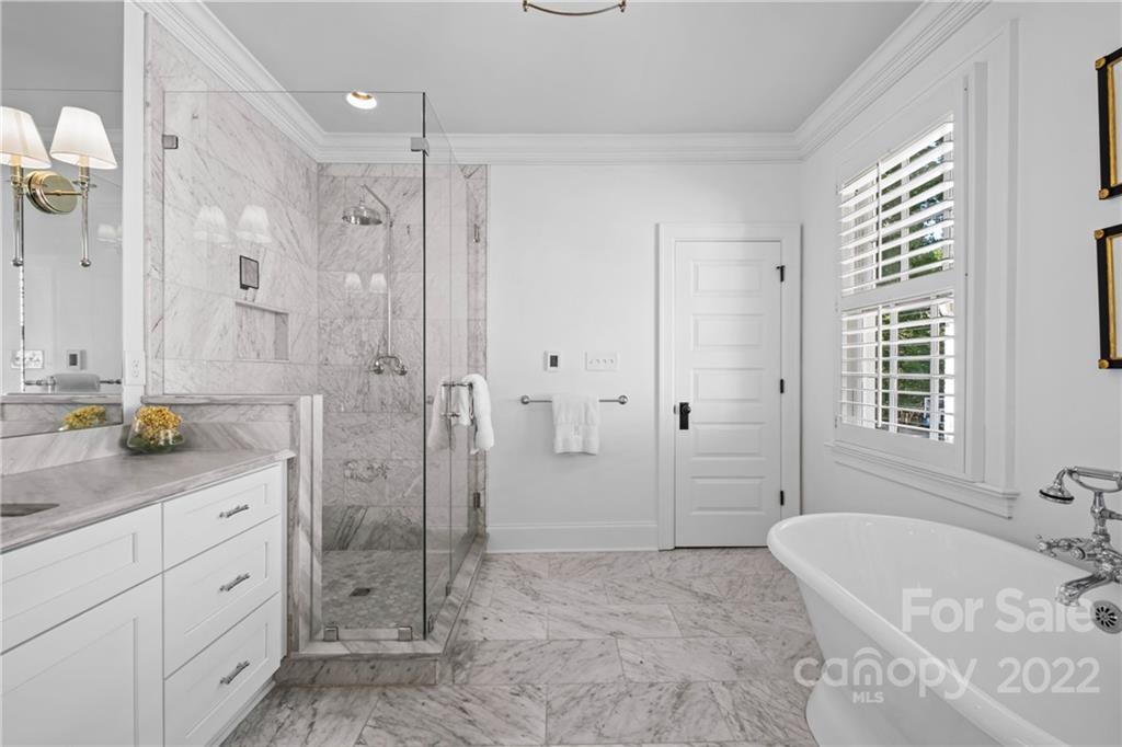 2156 Colony Road Charlotte, NC 28209 - Photo 30 of 46 a spacious bathroom with a granite countertop tub sink a mirror a shower and vanity